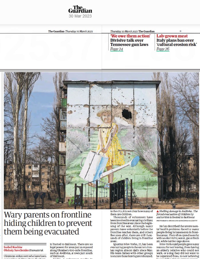 Газетна стаття з The Guardian від 30 березня 2023 року. У верхній частині зображення – заголовок газети. Нижче – велике фото стіни з пошкодженим малюнком дівчинки, яка поливає квіти. Ліворуч і праворуч від стіни видно дерева та житлові будинки. Заголовок статті: 'Батьки на передовій ховають дітей, щоб запобігти їх евакуації'. Текст статті описує ситуацію в Бахмуті та інших районах уздовж лінії фронту в Україні, де волонтери допомагають цивільним жителям, включаючи дітей.